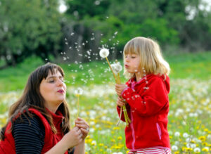 Mother and daughter blowing dandelions