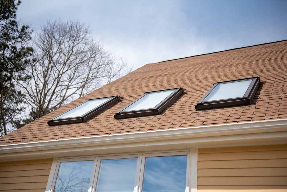 Triple,Skylights,On,Red,Roof,With,Yellow,Siding,And,Blue